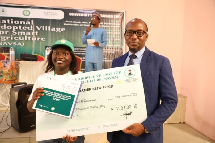 Dr Ayodele Bakare presenting a dummy cheque of #100, 000 seed fund and a tablet to one of the beneficiaries at closing ceremony of NAVSA empowerment program at University of Ibadan.